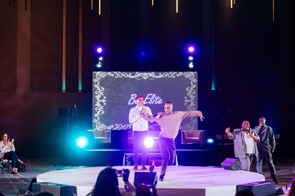 Two men dance on stage at the Biomedical H.I.V. Summit