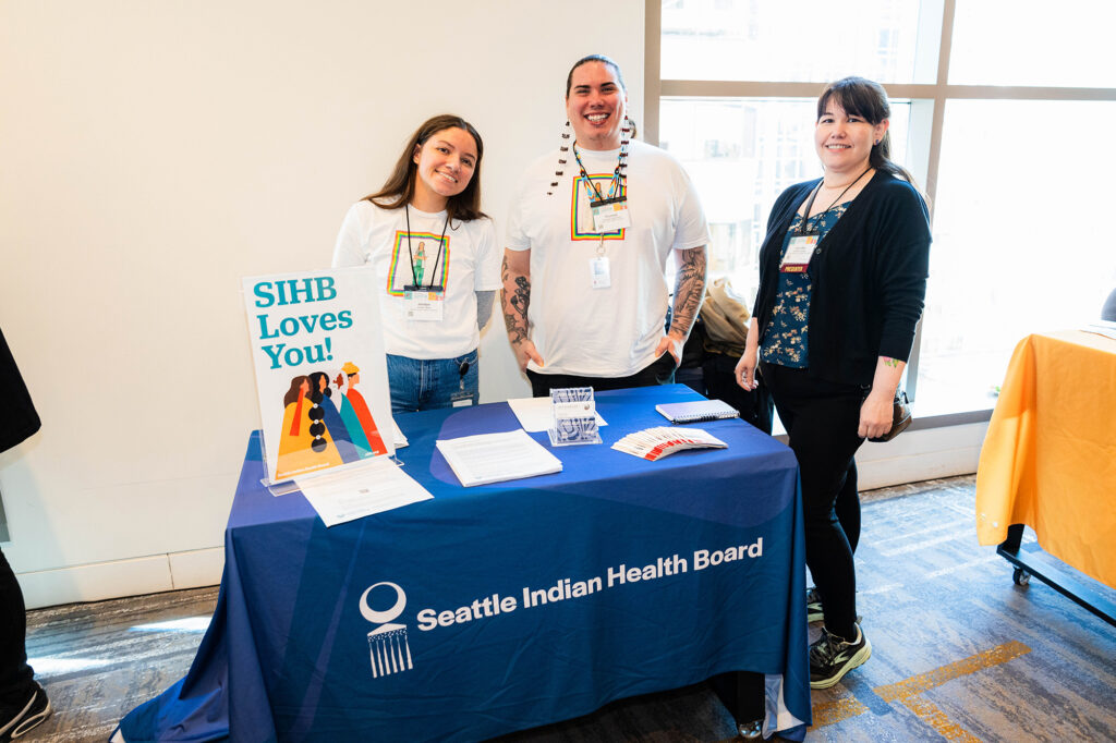 Three women standing behind the Seattle Indian Health Board