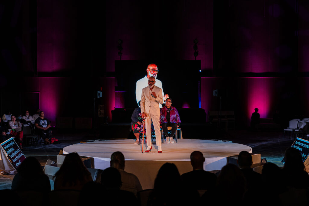 A speaker on stage at the Biomedical H.I.V. Summit