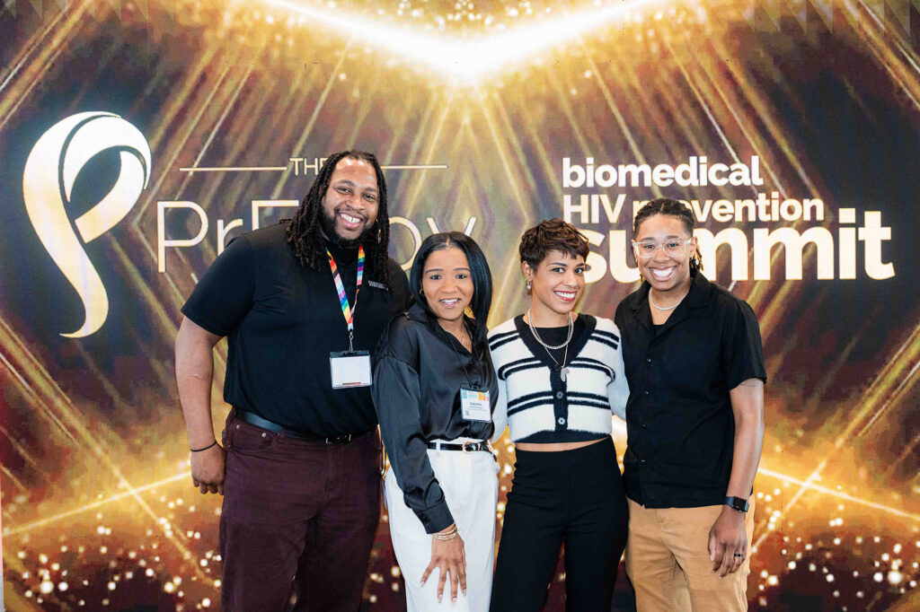 People pose in front of the Summit's conference banner.