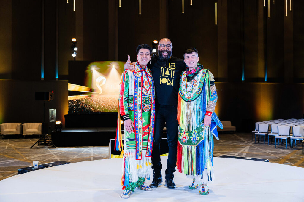 People in native American garb pose at the. Biomedical H.I.V. Summit