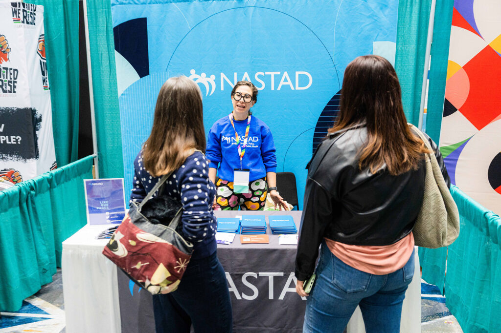 A conference goers interacting with an Exhibitor.